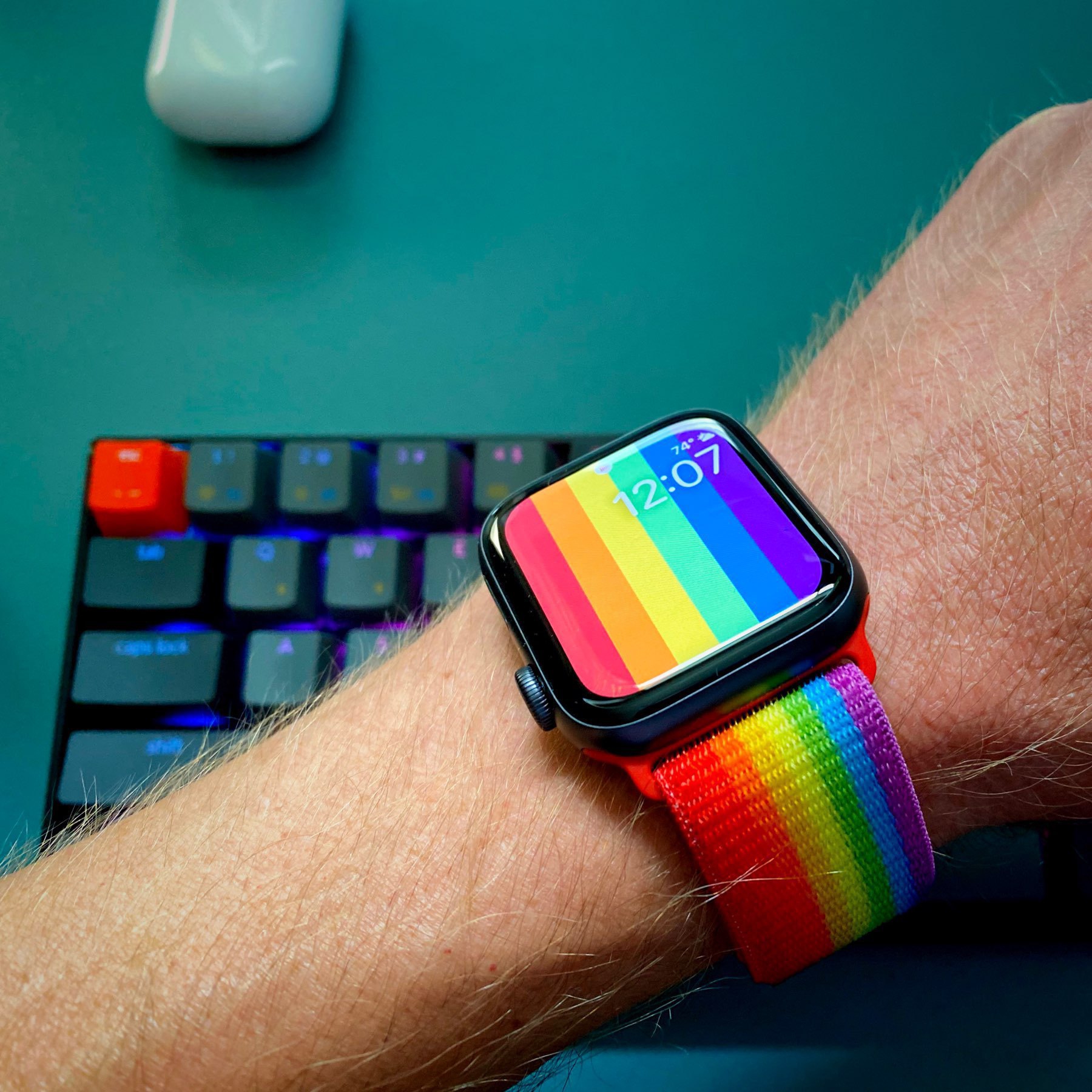 Wrist wearing a rainbow Apple Watch band