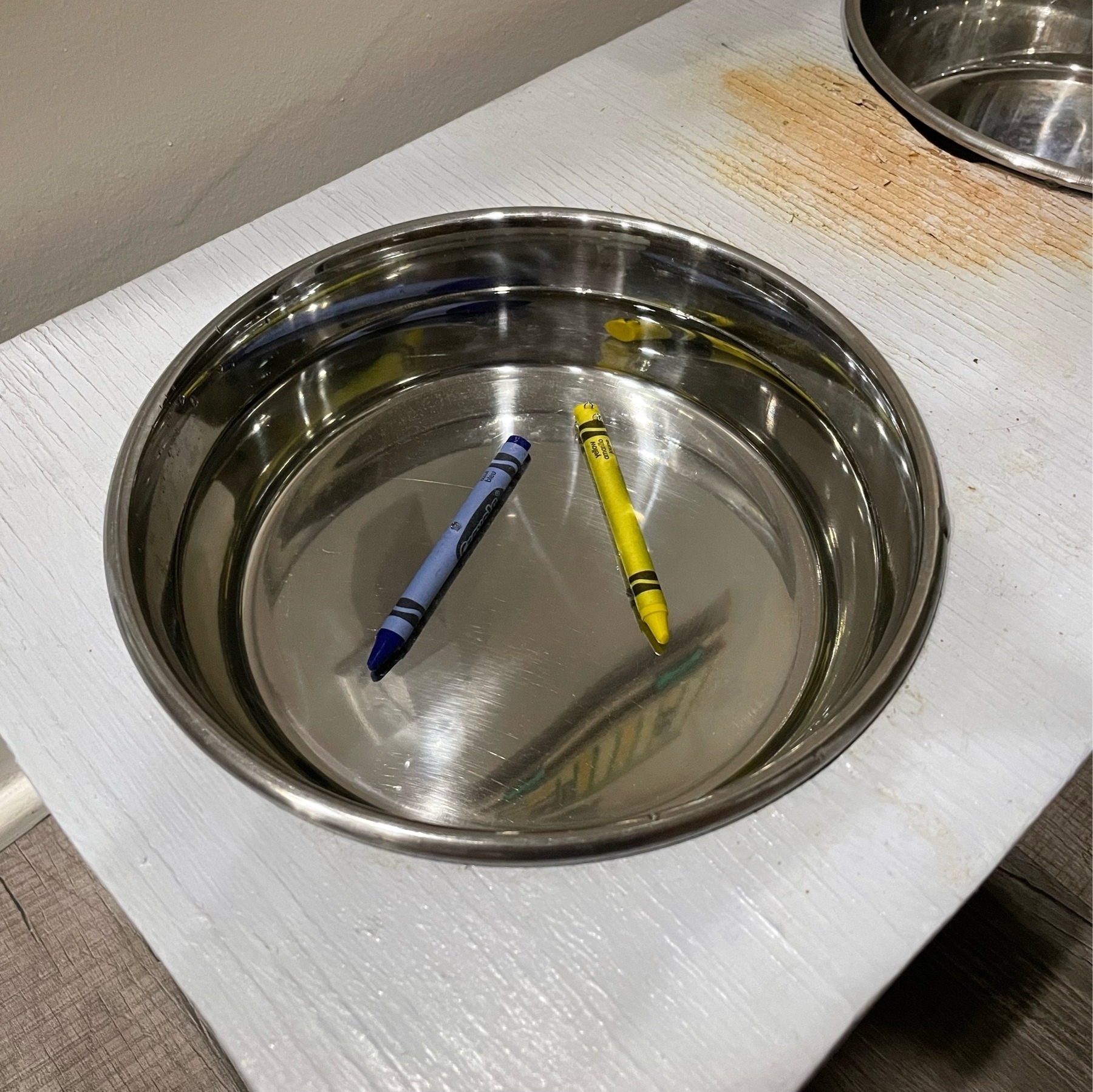 two crayons in a water dish